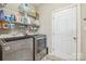 Well-lit laundry room with modern washer and dryer units and ample shelving at 9137 Brightleaf Pl, Charlotte, NC 28269