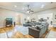 Open-concept living room with hardwood floors, a large gray sectional, and easy access to the kitchen at 9137 Brightleaf Pl, Charlotte, NC 28269