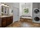 Bright bathroom features travertine floors, built in tub, modern fixtures and laundry closet at 9261 Marvin School Rd, Marvin, NC 28173