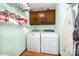 Functional laundry room with a washer, dryer, overhead cabinets, and storage shelf space at 9319 Chislehurst Rd, Mint Hill, NC 28227