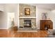 Living room featuring a cozy stone fireplace, hardwood floors, and a decorative desk at 9319 Chislehurst Rd, Mint Hill, NC 28227