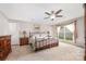 Comfortable main bedroom features a ceiling fan, neutral colors, and a large window to welcome natural light at 9319 Chislehurst Rd, Mint Hill, NC 28227