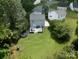Aerial view of home with spacious backyard featuring deck, trampoline, and lush greenery at 1003 Snake River Ct, Monroe, NC 28110
