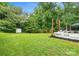 Large backyard with a shed, swing set, and wooden deck, surrounded by green trees at 1003 Snake River Ct, Monroe, NC 28110