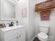 Bright powder room featuring a white vanity, toilet, a decorative mirror, and light cherry upper cabinets at 1003 Snake River Ct, Monroe, NC 28110