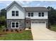 Charming two-story home with stone accents, white siding, attached garage, and a well-manicured lawn at 10339 Lakeshore Dr # 85, Lancaster, SC 29720