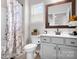 Well-lit bathroom with a vanity, white cabinets, decorative shower curtain, and large mirror at 106 Tuppy Ct, Statesville, NC 28625