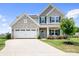 Beautiful two-story home with stone accents, blue shutters, landscaped yard, and a two-car garage at 106 Tuppy Ct, Statesville, NC 28625