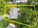Aerial view of the property showcasing a manicured lawn, mature trees, a pool, and a trampoline at 10919 Valley Spring Dr, Charlotte, NC 28277