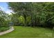 Expansive backyard with lush lawn and mature trees, ideal for recreation and enjoying nature at 10919 Valley Spring Dr, Charlotte, NC 28277