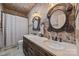 Bathroom with double sinks, decorative mirrors, and tiled walls at 10919 Valley Spring Dr, Charlotte, NC 28277
