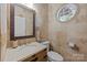 Powder room with stone walls, mirror and a sink at 10919 Valley Spring Dr, Charlotte, NC 28277