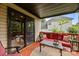 Covered outdoor deck with a red outdoor couch, a table and a view of the yard at 10919 Valley Spring Dr, Charlotte, NC 28277