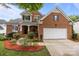 Charming brick home with a two-car garage, landscaped yard, and a welcoming covered front porch at 10919 Valley Spring Dr, Charlotte, NC 28277