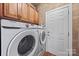 This laundry room features a washer and dryer with wooden cabinets overhead at 10919 Valley Spring Dr, Charlotte, NC 28277