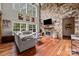 Bright living room featuring a stone fireplace, large windows, and hardwood floors at 10919 Valley Spring Dr, Charlotte, NC 28277