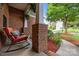 Cozy front porch with a rocking chair, decorative cushions, plants, and a view of the landscaped yard at 10919 Valley Spring Dr, Charlotte, NC 28277