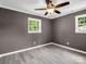 Bedroom featuring neutral walls, durable light wood-look flooring, and natural light from two windows at 111 Wolfe Rd, Shelby, NC 28152
