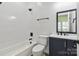 Bright bathroom featuring a tub-shower, modern fixtures, and a vanity with a navy blue cabinet at 113 Woodside Ave, Gastonia, NC 28054