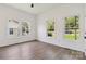 Bright bedroom features wood-look floors, white walls, windows, and a view of yard at 113 Woodside Ave, Gastonia, NC 28054