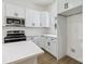 White kitchen cabinets and stainless steel appliances, including a microwave and range, with quartz countertop at 113 Woodside Ave, Gastonia, NC 28054