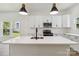 Close up view of a kitchen island with quartz countertop, stainless sink, and black faucet at 113 Woodside Ave, Gastonia, NC 28054