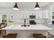 Up-close view of a modern kitchen island with a sleek faucet, white countertops, and pendant lighting at 113 Woodside Ave, Gastonia, NC 28054