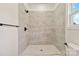 Bathroom featuring walk-in shower with gray tiles, black hardware, and bright window at 113 Woodside Ave, Gastonia, NC 28054