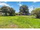 Large, open yard with mature trees and a clear view to a house in the distance at 113 Woodside Ave, Gastonia, NC 28054