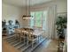 Inviting dining room featuring a large wooden table, stylish chairs, and an abundance of natural light at 11404 James Coy Rd, Davidson, NC 28036