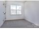 Neutral bedroom features a window with tree-lined views, and carpeted floors at 118 Durham Rd, Stanley, NC 28164