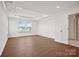 Spacious bedroom featuring tray ceilings, hardwood floors, and an ensuite bathroom at 12009 Grinstead Ln # 303, Charlotte, NC 28278