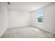 Bright, neutral bedroom with plush carpeting, recessed lighting, and a large window offering outdoor views at 12009 Grinstead Ln # 303, Charlotte, NC 28278