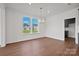 Inviting dining room featuring hardwood floors, modern lighting fixture, neutral walls, and natural light at 12009 Grinstead Ln # 303, Charlotte, NC 28278
