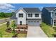 Charming two-story home showcasing manicured landscaping, a welcoming porch, and an attached two-car garage at 12009 Grinstead Ln # 303, Charlotte, NC 28278