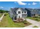 Beautiful two-story home with lush green lawn, showcasing the side yard and inviting front porch at 12009 Grinstead Ln # 303, Charlotte, NC 28278