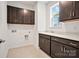 Convenient laundry room with storage cabinets, a utility sink, and connections for a washer and dryer at 12009 Grinstead Ln # 303, Charlotte, NC 28278