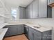 Well-organized pantry featuring gray cabinets, white countertops, open shelving, and stainless-steel appliances at 12009 Grinstead Ln # 303, Charlotte, NC 28278