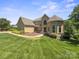 Stunning home featuring a well-manicured lawn, beautiful landscaping, and unique architectural details at 122 Long Cove Ln, Mooresville, NC 28117