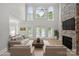 Spacious living room with a stone fireplace, large windows, and modern decor at 122 Long Cove Ln, Mooresville, NC 28117