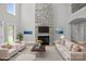Cozy living room featuring stone fireplace, high ceilings, and ample natural light at 122 Long Cove Ln, Mooresville, NC 28117