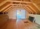 Unfinished attic space with exposed rafters, wood flooring, and door to storage or additional area at 1238 Shinnville Rd, Cleveland, NC 27013