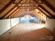Spacious unfinished attic with exposed wood beams, potential for renovation, and ample storage at 1238 Shinnville Rd, Cleveland, NC 27013