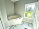 Elegant bathroom featuring a corner jacuzzi tub and a window with scenic outdoor views at 1238 Shinnville Rd, Cleveland, NC 27013