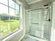 Modern bathroom shower featuring glass door, tile surround, and natural light from a large window at 1238 Shinnville Rd, Cleveland, NC 27013