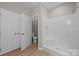 Bathroom featuring a step-in shower with white tiled walls, and white fixtures at 126 Aurora Blvd, Matthews, NC 28105