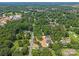 Overhead view of a home and neighborhood with dense tree coverage, featuring well-kept lawns at 130 Aurora Blvd, Matthews, NC 28105