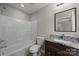 Well-lit bathroom featuring a shower-tub combo and modern vanity with a marble countertop at 130 Aurora Blvd, Matthews, NC 28105
