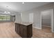 An open kitchen and living area features a kitchen island and wood-look flooring at 130 Aurora Blvd, Matthews, NC 28105