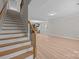 Open-concept living room with wood-look flooring, staircase, and views to the kitchen at 130 Aurora Blvd, Matthews, NC 28105